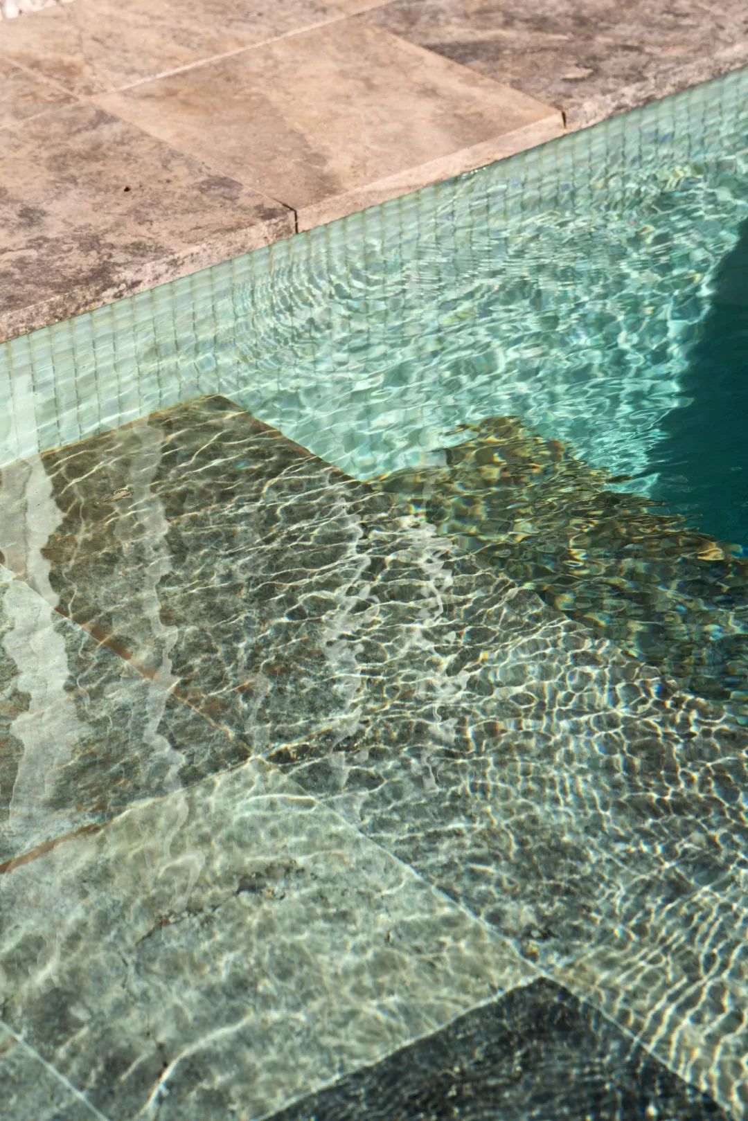 Close-up of a swimming pool edge with rippling water